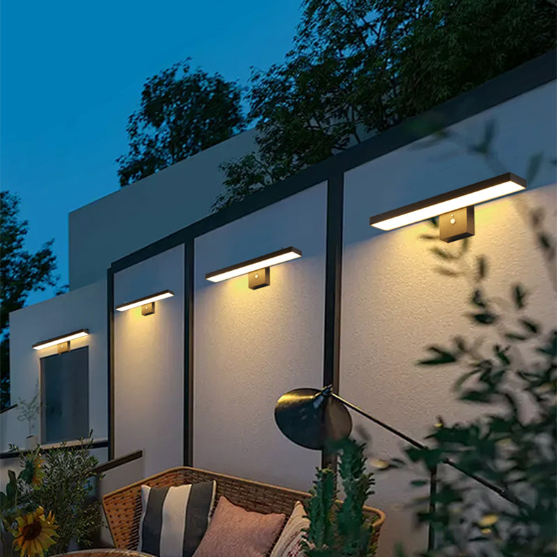 Modern outdoor setting with wall-mounted lights and a seating area.